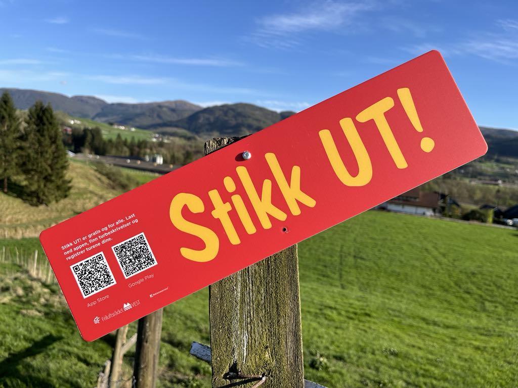 StikkUT-logo oppå eit bilde av grøn mark og blå himmel - Klikk for stort bilde