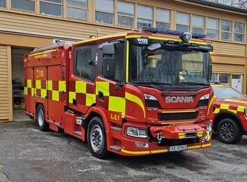 Raud og gul brannbil utanfor stasjonen - Klikk for stort bilde