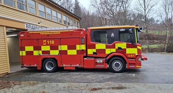 Raud og gul brannbil utanfor stasjonen - Klikk for stort bilde